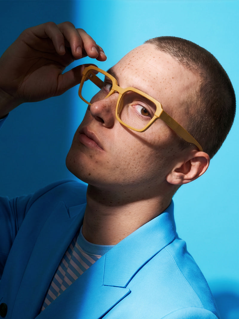 Close-up of Blynq Quad square glasses in Dune worn by a model
