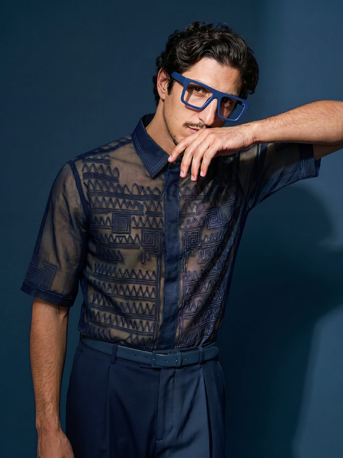 Editorial shot of a model in a navy sheer shirt wearing Blynq Solo Indigo frames