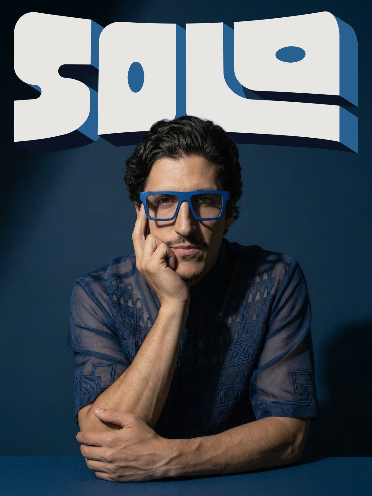 Solo campaign cover: model in a navy sheer shirt wearing Blynq Solo square glasses in Indigo